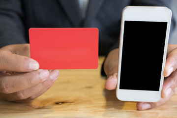 male showing a credit card and mobile smart phone for online shopping. businessman purchase goods from internet. man make payment on bank website