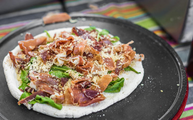 Tortilla with arugula, parma jamon ham, and parmesan cheese at a street food market