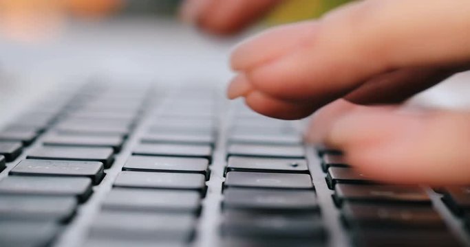 Closeup of business woman hand typing on laptop keyboard. Closeup of a female hands busy typing on a laptop. Woman's hands tapping pressing keys on a portable laptop keyboard trying to access data 4k