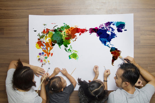 Top view happy family lying on floor with painting watercolor world map on paper background