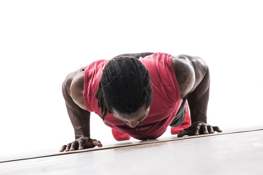 Unrecognizable Black Young Man In Studio Doing Push-ups On The Floor. Tilted Shot