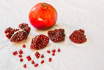 Ripe and red pomegranate fruit with seeds against white background