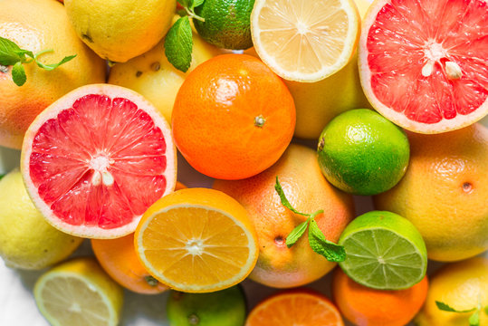 A large assortment of colorful citrus fruit (lemon, lime, orange, grapefruit, mandarin, tangerine, pomelo)