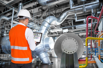 Engineer using laptop computer for maintenance in thermal power plant factory