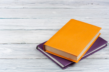 Colorful books on white wooden table. Copy space for text. Back to School.
