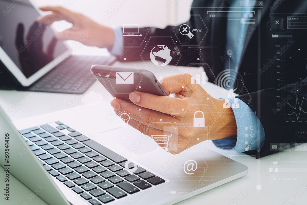 Poster Hands of businessman using mobile phone in modern office with laptop and digital tablet computer