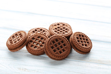 Chocolate cookies with cream on white wooden table