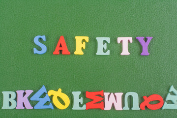SAFETY word on green background composed from colorful abc alphabet block wooden letters, copy space for ad text. Learning english concept.