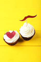 Tasty cupcakes on yellow wooden table
