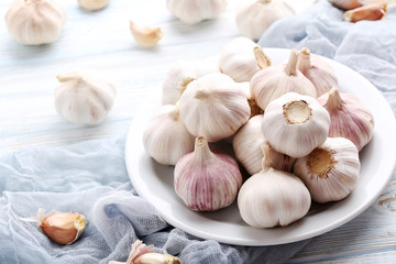 Garlic in plate on blue wooden table