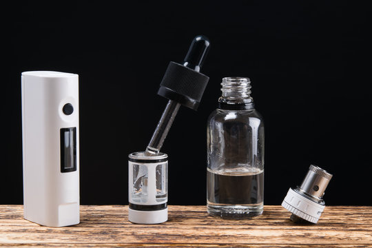 vaping set and liquid with  on a dark background