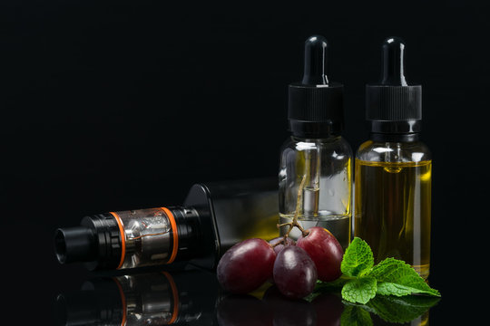 Set for vaping with grapes aroma in bottles, on a dark background