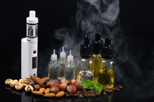 the concept of electronic cigarettes and nuts on a background of smoke