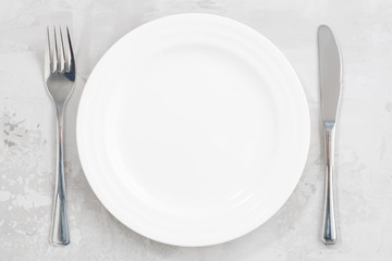 concept photo. White empty plate and cutlery, closeup