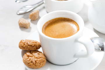 cup of espresso and almond cookies on a white table, closeup
