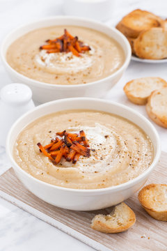 cream soup with caramelized carrots in bowl, vertical
