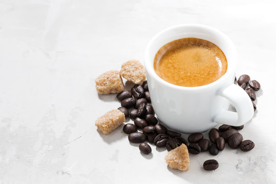 cup of espresso and sugar on a white table, closeup