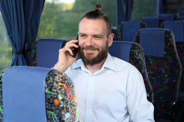 Fototapeta Wycieczka autokarowa. Pasażer rozmawia przez telefon w czasie podróży. obraz
