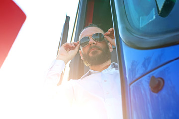 Kierowca autobusu poprawia okulary przeciwsłoneczne.Przystojny kierowca autobusu. - obrazy, fototapety, plakaty
