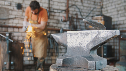 Blacksmith working a circular saw about anvil