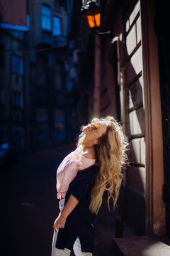 Look From Behind At Blonde Woman Posing In Blue Shirt In The Rays Of Sun