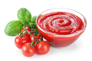 Bowl with ketchup basil and tomatoes isolated on white background.