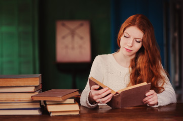 indoor lifestyle autumn portrait of young redhead woman reading book in cozy interior, enjoying cold weekend day at home 