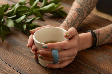 Fototapeta na wymiar Female hands holding coffee cup