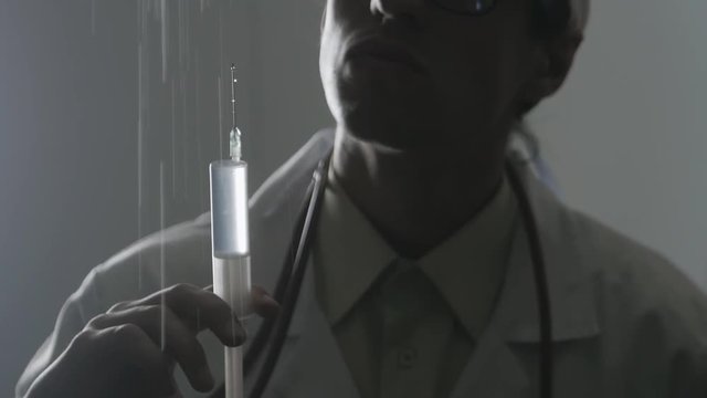 Portrait of a doctor with a syringe. An injection