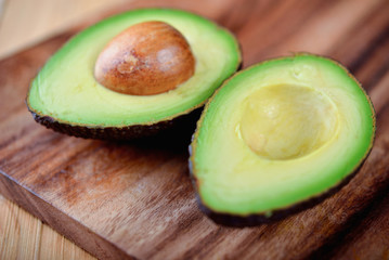 selected focus half cut ripe avocado with seed on board