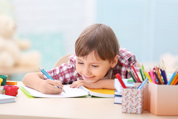 Cute little boy studying at home