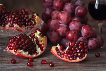 Juicy pomegranate with red grape and red wine. Still life with pomegranate.