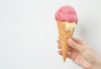 Woman holding portion of delicious ice cream on white background