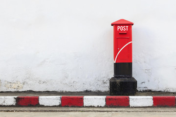 Fototapeta na wymiar old red postbox on the street. over light
