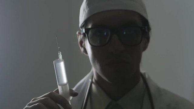 Portrait of a doctor with a syringe. An injection