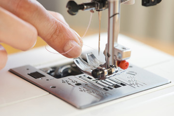 Macro close up of tailor threading sewing machine