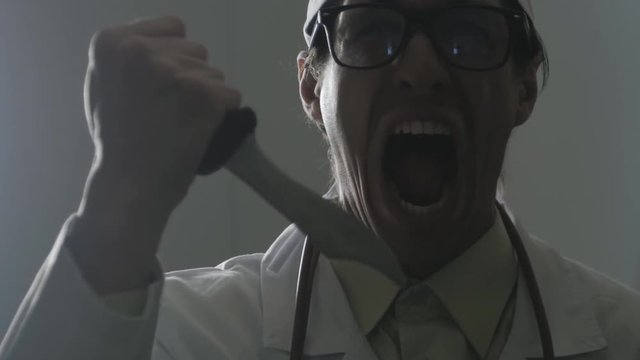 Portrait of a mad doctor with a knife in his hands