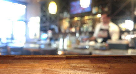 Empty wooden table top with blurred bar on background