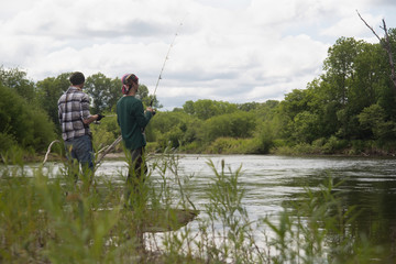 Two fishermen fish in a calm river, pacifying photo