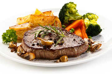 Grilled beefsteak with broccoli and carrot on white background