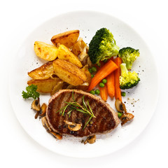 Grilled beefsteak with broccoli and carrot on white background