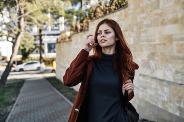 Fototapeta premium Woman in a raincoat on a brick wall background