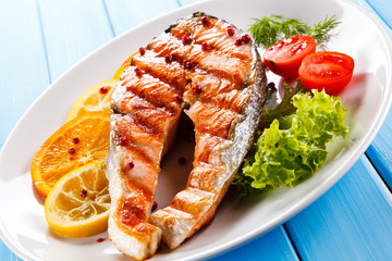 Grilled salmon with vegetables on blue wooden table