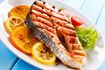 Grilled salmon with vegetables on blue wooden table
