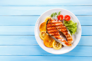 Grilled salmon with vegetables on blue wooden table