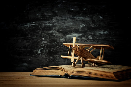 Toy plane and the open book on wooden table