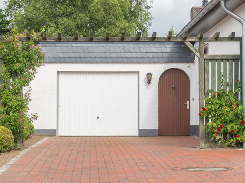 Garage mit weißem Tor und brauner Tür