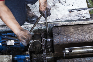 repairman holding a wrench and tighten and during maintenance work of machine
