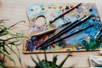 High angle view of artist palette with paint brushes and palette knife on the top