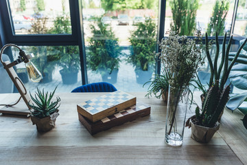 Studio workplace with chess boards, artistic work tools and green plants